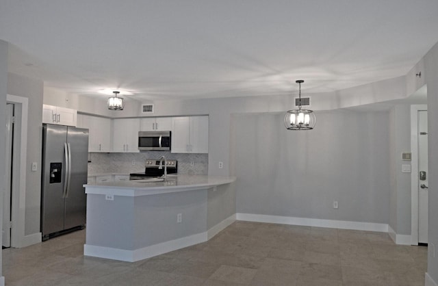 kitchen featuring pendant lighting, white cabinets, kitchen peninsula, stainless steel appliances, and an inviting chandelier