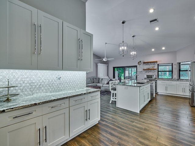 kitchen featuring sink, light stone counters, white cabinetry, dark hardwood / wood-style floors, and backsplash