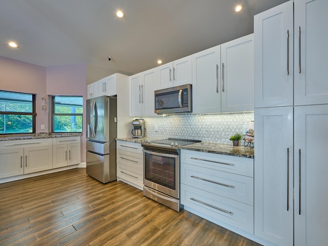 kitchen featuring stone counters, dark hardwood / wood-style floors, white cabinetry, backsplash, and stainless steel appliances