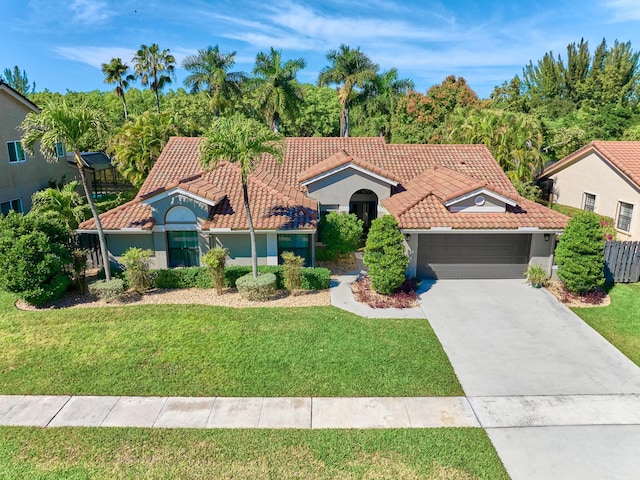 mediterranean / spanish house with a garage and a front yard