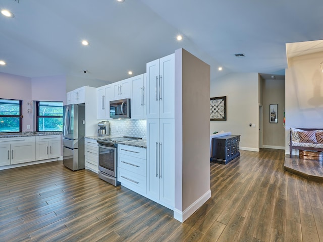 kitchen with appliances with stainless steel finishes, white cabinets, and light stone counters