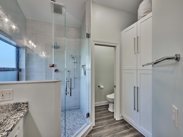 bathroom featuring walk in shower, vanity, and toilet