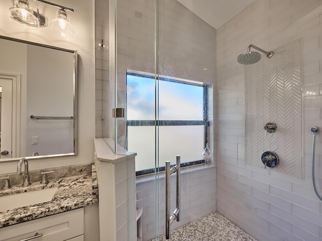 bathroom featuring a water view, tiled shower, and vanity