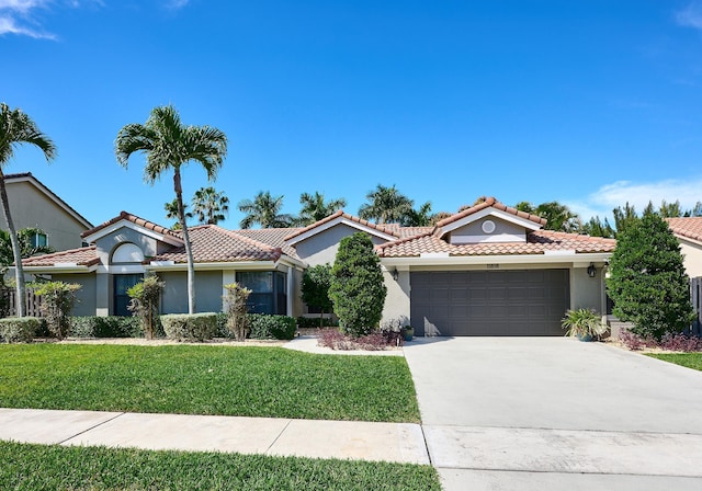 mediterranean / spanish-style home with a garage and a front lawn