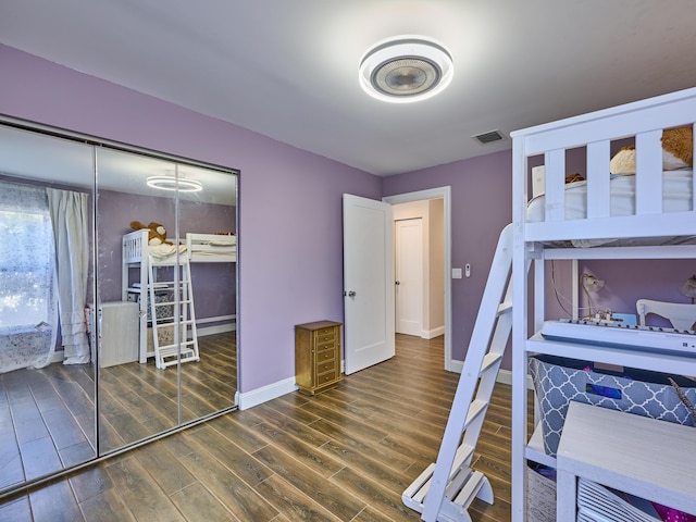 bedroom with dark wood-type flooring and a closet