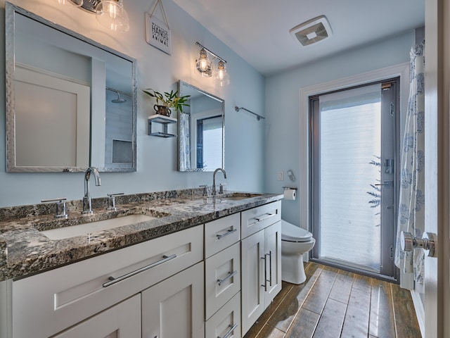 bathroom featuring wood-type flooring, vanity, and toilet