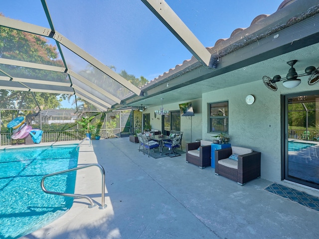 view of swimming pool featuring an outdoor living space, a patio, ceiling fan, and glass enclosure