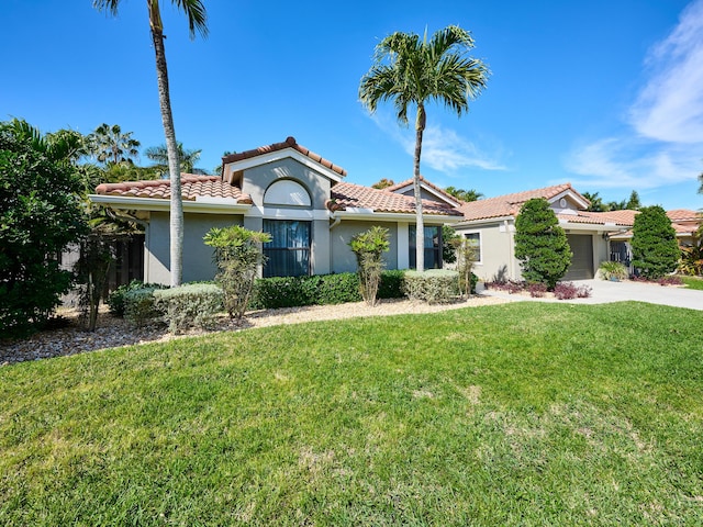 mediterranean / spanish-style home featuring a garage and a front yard