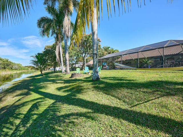 view of yard with a water view and a lanai