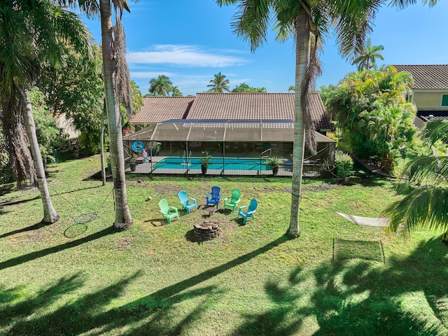 view of jungle gym with a fire pit, a lawn, and a lanai