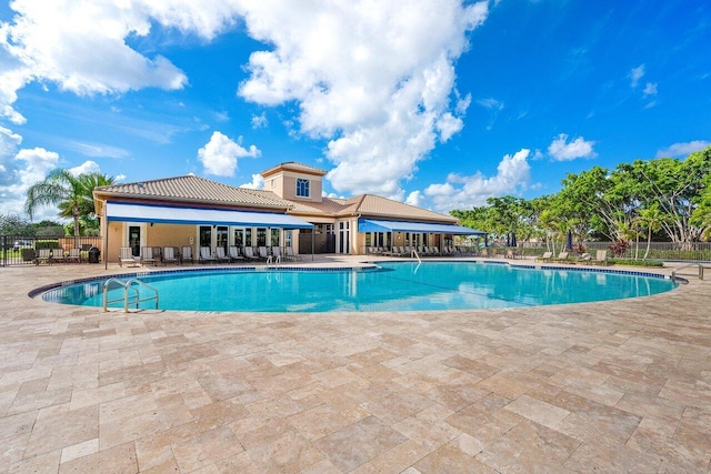 pool with fence and a patio