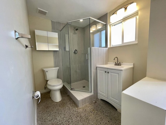 bathroom with vanity, toilet, and a shower with shower door