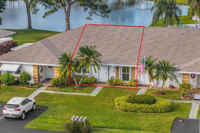 single story home with a front lawn and a water view