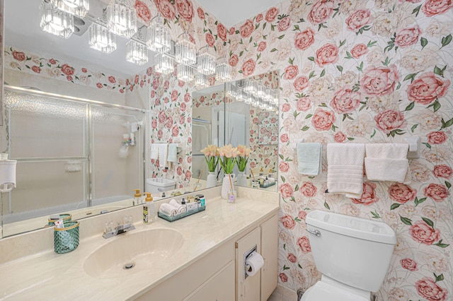 bathroom with an enclosed shower, vanity, and toilet