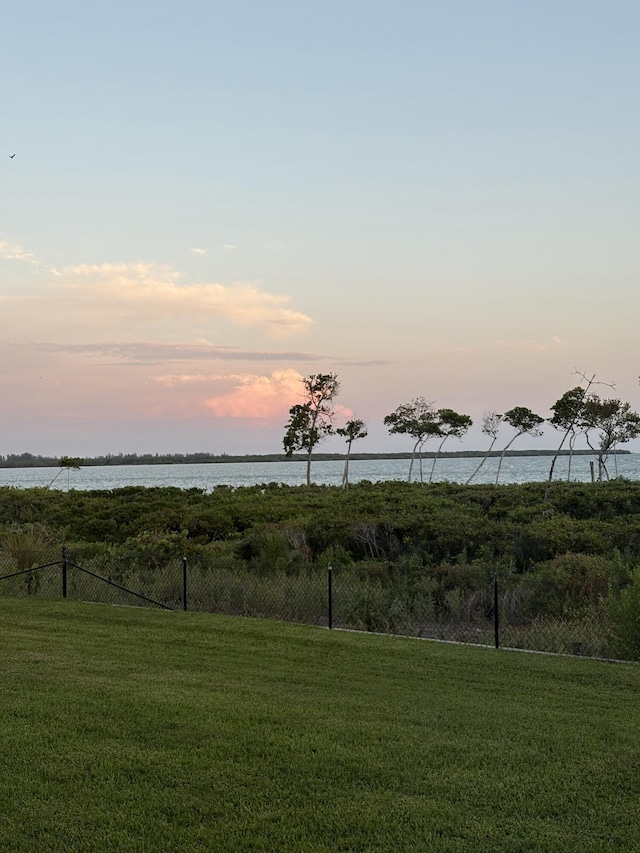 view of yard with a water view and fence