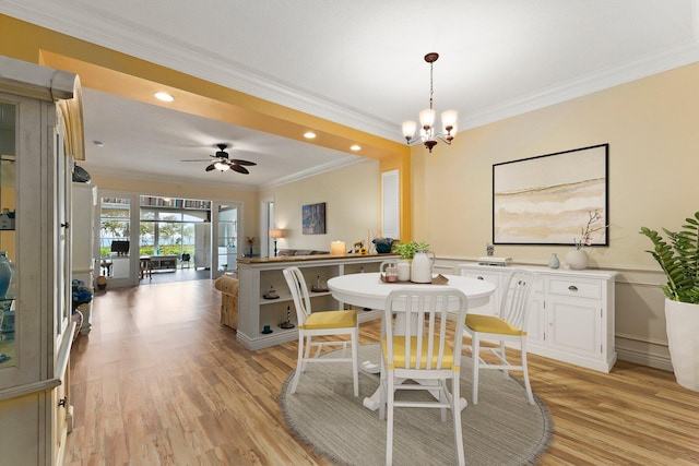 dining space featuring ceiling fan with notable chandelier, ornamental molding, and light hardwood / wood-style floors