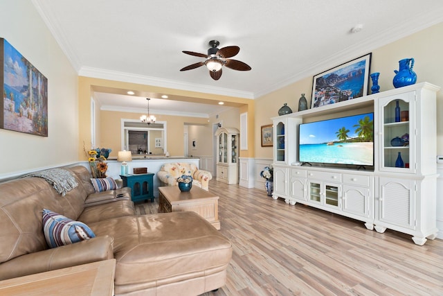 living room with ceiling fan with notable chandelier, light hardwood / wood-style flooring, and ornamental molding