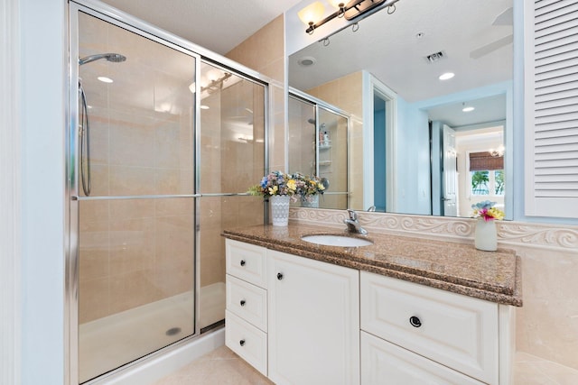 bathroom with vanity and a shower with door