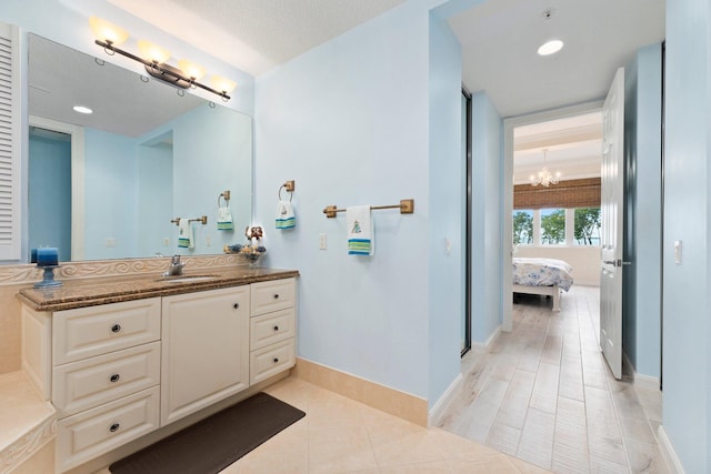 bathroom featuring vanity, tile patterned floors, and an inviting chandelier