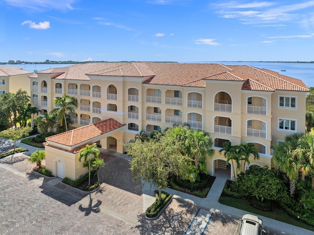 view of building exterior with a water view and decorative driveway