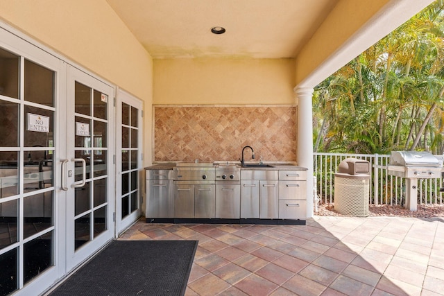 view of patio with a grill, french doors, area for grilling, and a sink