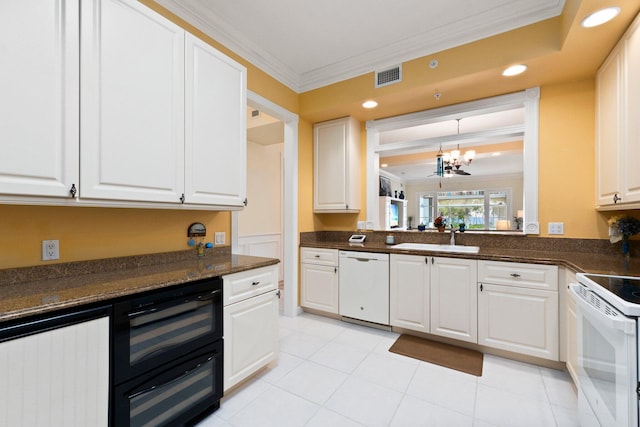 kitchen featuring white cabinetry, crown molding, white appliances, and a sink