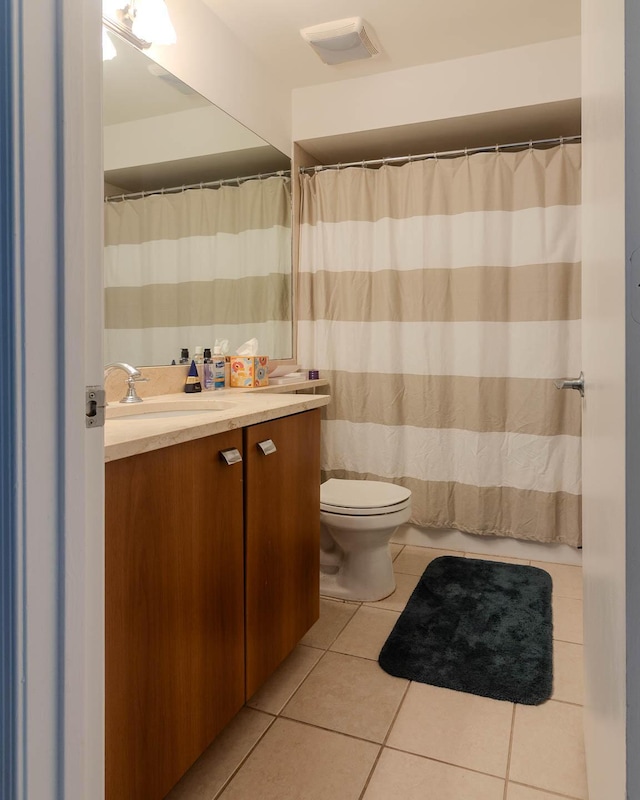 bathroom with tile patterned flooring, vanity, and toilet