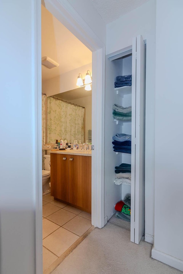 bathroom featuring a shower with curtain, tile patterned floors, vanity, and toilet