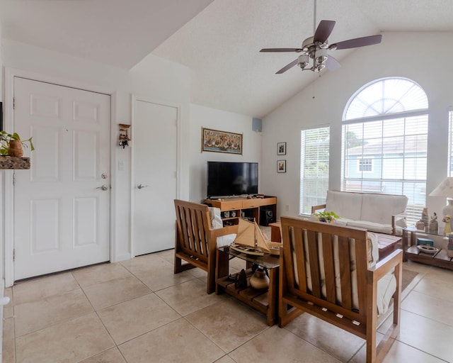 living room with ceiling fan, lofted ceiling, and light tile patterned floors