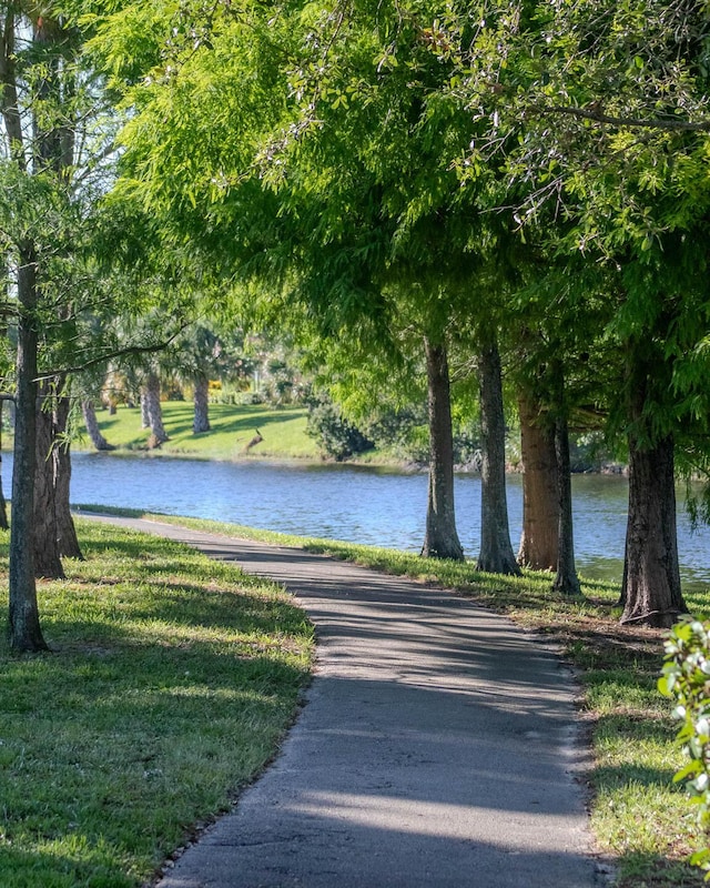 surrounding community featuring a water view and a lawn