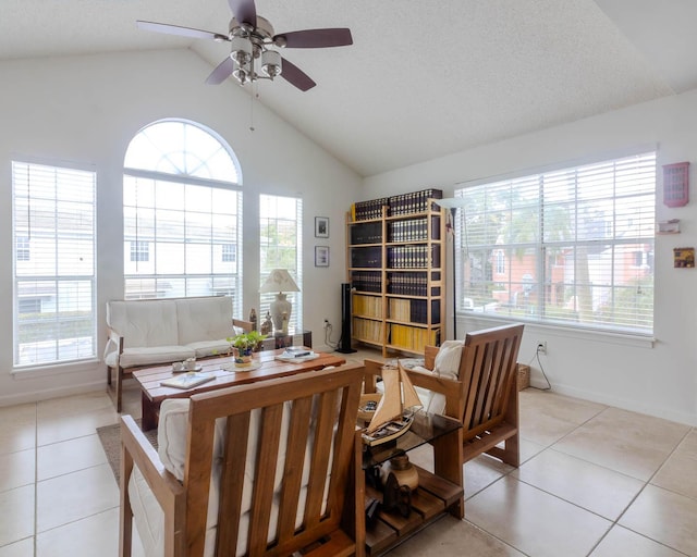 sitting room with ceiling fan, vaulted ceiling, and light tile patterned floors