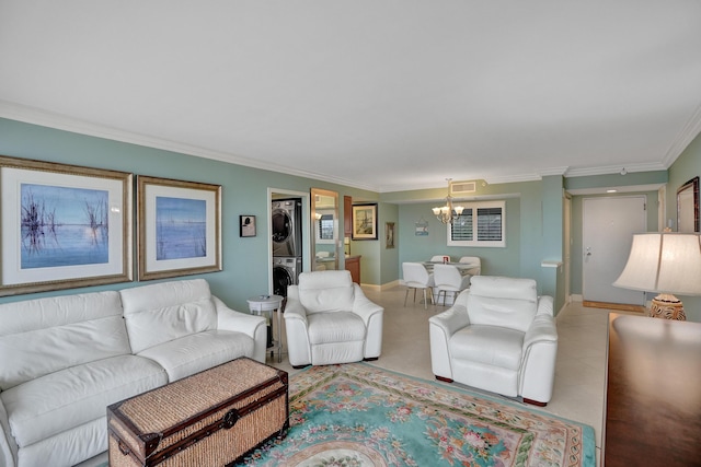 living room with ornamental molding, stacked washer / drying machine, and a chandelier