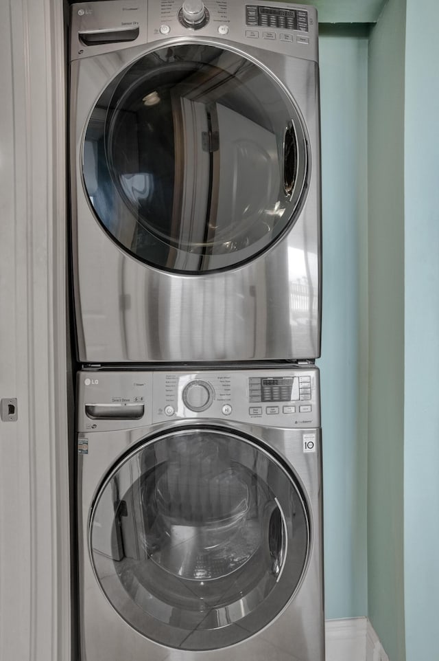 clothes washing area featuring stacked washer and clothes dryer