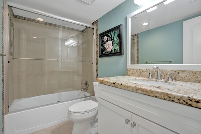 full bathroom featuring tile patterned flooring, bath / shower combo with glass door, vanity, and toilet