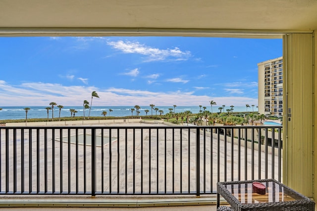 balcony with a water view and a beach view