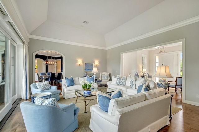 living room featuring an inviting chandelier, hardwood / wood-style flooring, ornamental molding, and a healthy amount of sunlight