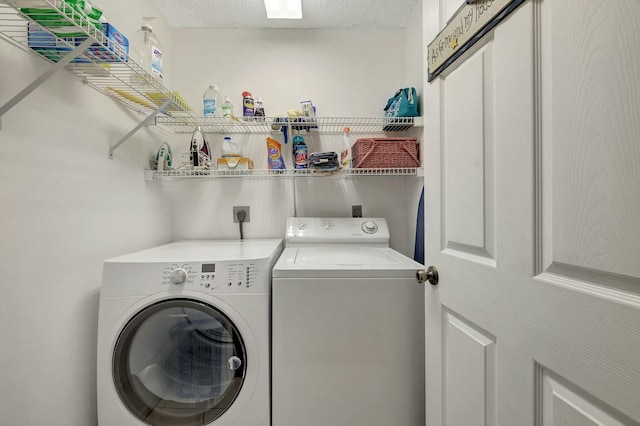 laundry area featuring washing machine and dryer and a textured ceiling