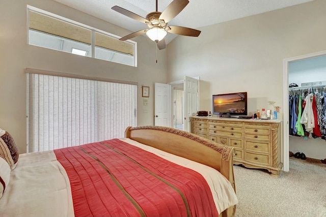 bedroom with a towering ceiling, carpet flooring, a spacious closet, ceiling fan, and a closet