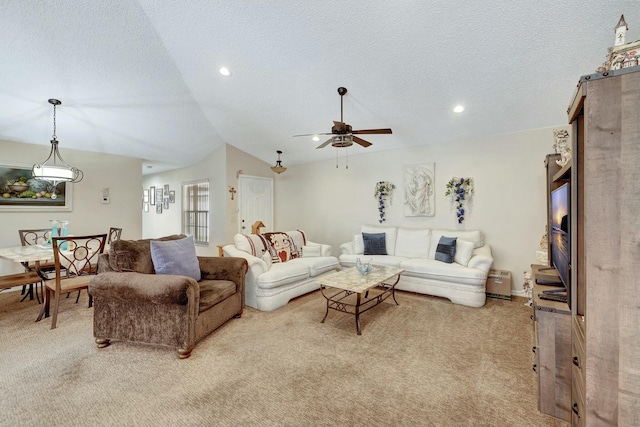 carpeted living room featuring ceiling fan, vaulted ceiling, and a textured ceiling