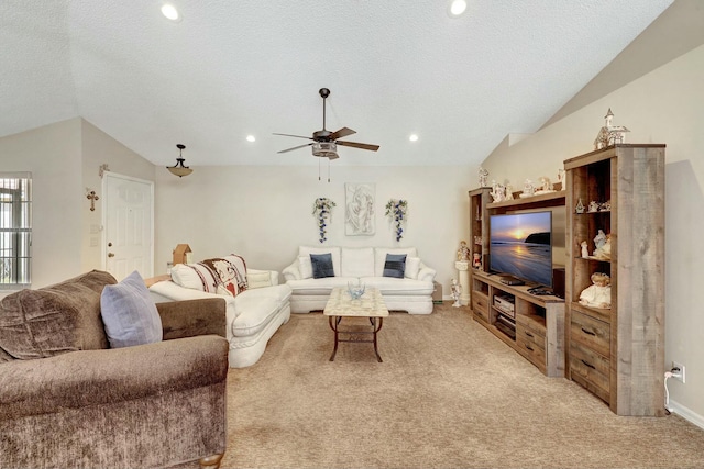 living room featuring ceiling fan, lofted ceiling, light carpet, and a textured ceiling