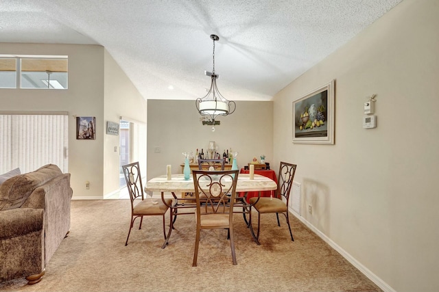 dining room with light colored carpet, lofted ceiling, and a textured ceiling