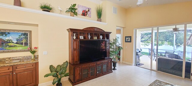 tiled living room featuring a towering ceiling and ceiling fan