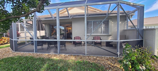 back of house featuring a lanai and a patio area