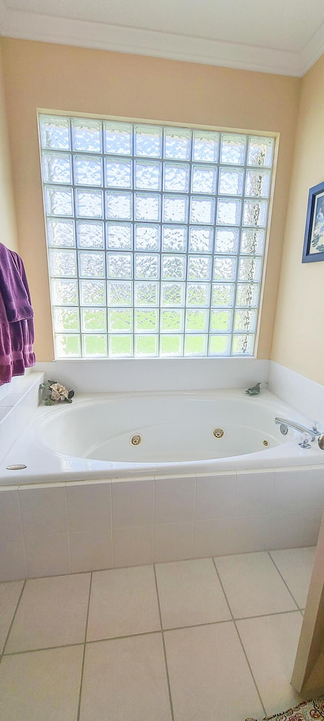 bathroom featuring ornamental molding, tiled bath, and tile patterned flooring