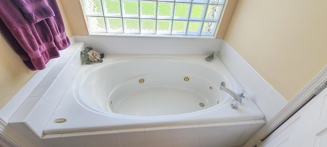 bathroom with a healthy amount of sunlight and tiled tub