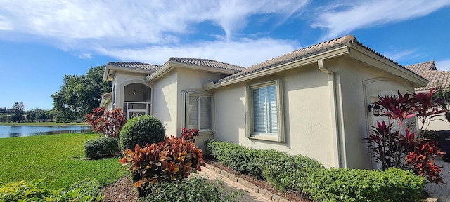 view of side of property with a water view and a lawn