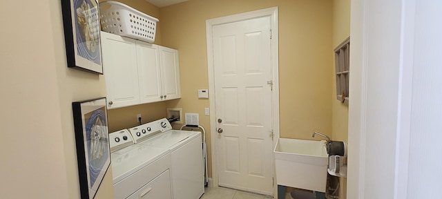 laundry area with light tile patterned flooring, cabinets, washer and clothes dryer, and sink