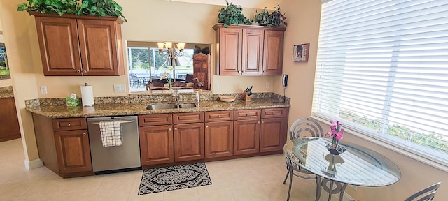 kitchen with dark stone countertops, sink, stainless steel dishwasher, and a healthy amount of sunlight