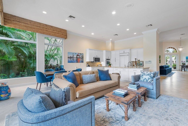 living room featuring ornamental molding, sink, and french doors