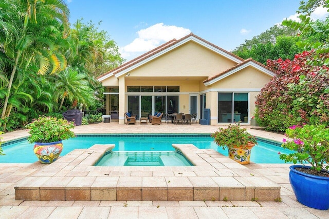 view of swimming pool featuring a patio area and an in ground hot tub